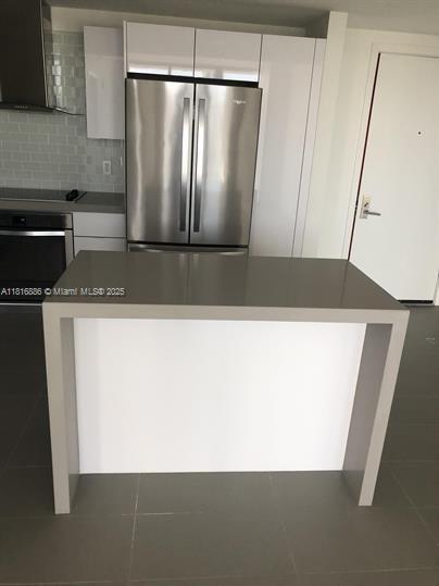 1600 NE 1st Ave Unit 3319, Miami, FL 33132 - kitchen with stainless steel appliances, extractor fan, white cabinetry, tile patterned floors, and backsplash