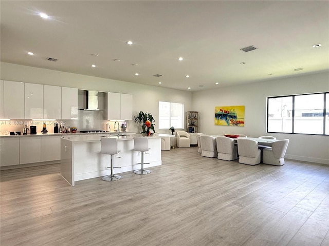 8167 NW 45th St, Doral, FL 33166 - kitchen with wall chimney range hood, modern cabinets, open floor plan, white cabinetry, and recessed lighting