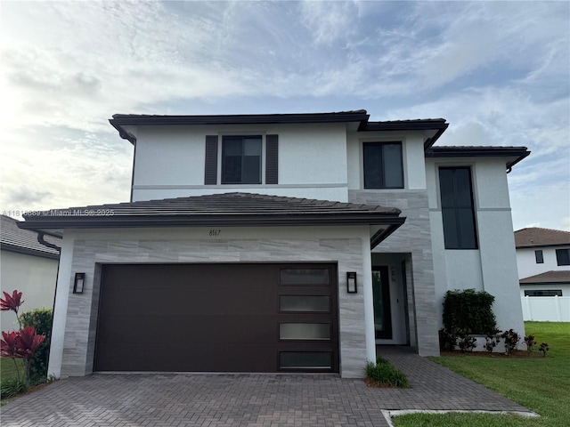 8167 NW 45th St, Doral, FL 33166 - view of front of house featuring stone siding, a garage, decorative driveway, stucco siding, and a front lawn