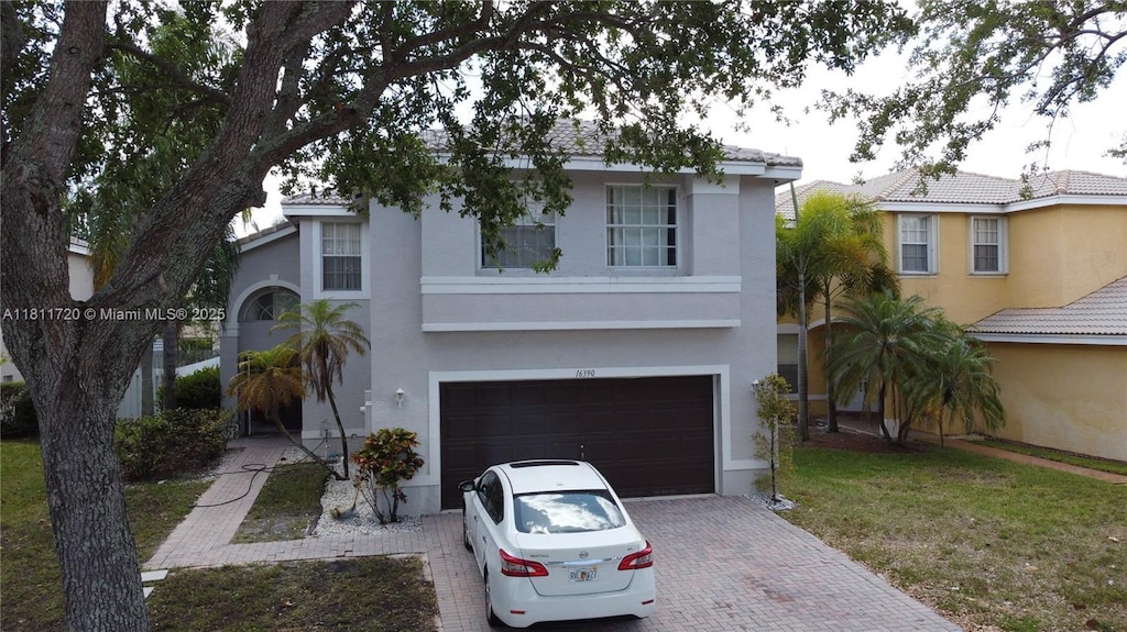 16390 SW 28th Ct, Miramar, FL 33027 - view of front of property featuring a garage, stucco siding, and decorative driveway
