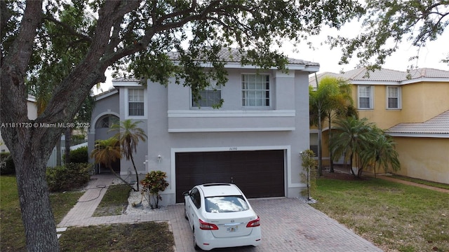 16390 SW 28th Ct, Miramar, FL 33027 - view of front of property featuring a garage, stucco siding, and decorative driveway