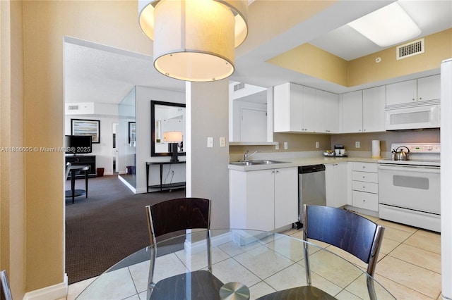 17375 Collins Ave Unit 1908, Sunny Isles Beach, FL 33160 - kitchen featuring white appliances, light countertops, white cabinets, a sink, and light tile patterned floors