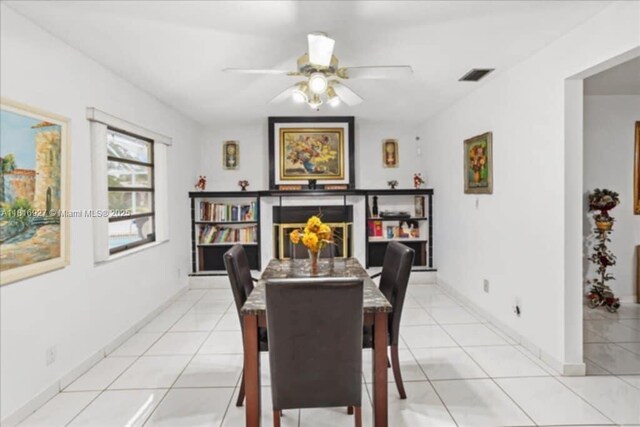 400 NW 41st Ave, Coconut Creek, FL 33066 - dining room featuring a ceiling fan, light tile patterned flooring, baseboards, and a fireplace
