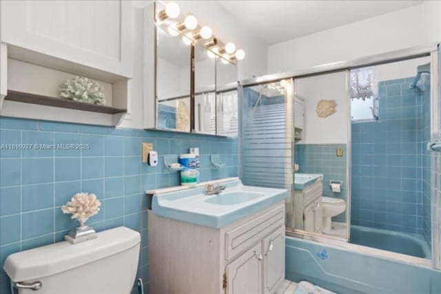 400 NW 41st Ave, Coconut Creek, FL 33066 - bathroom with toilet, tile walls, vanity, combined bath / shower with glass door, and a wainscoted wall