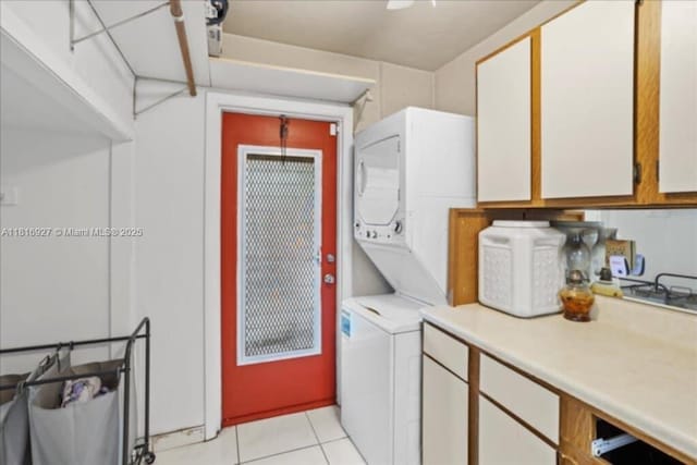 400 NW 41st Ave, Coconut Creek, FL 33066 - laundry room with stacked washing machine and dryer, light tile patterned flooring, and cabinet space