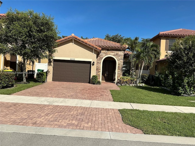 5220 NW 48th Ln, Tamarac, FL 33319 - mediterranean / spanish-style house featuring stone siding, stucco siding, a tile roof, an attached garage, and decorative driveway