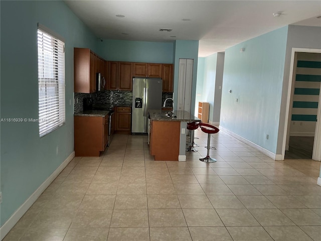 5220 NW 48th Ln, Tamarac, FL 33319 - kitchen featuring stainless steel appliances, a kitchen breakfast bar, backsplash, and healthy amount of natural light