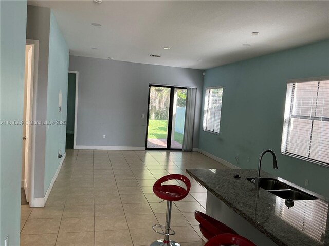 5220 NW 48th Ln, Tamarac, FL 33319 - kitchen featuring light tile patterned flooring, dark stone counters, and open floor plan