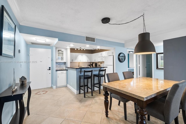 3725 S Ocean Dr Unit 1224, Hollywood, FL 33019 - dining area with a textured ceiling, ornamental molding, and light tile patterned floors