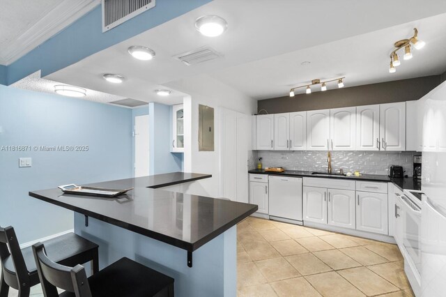 3725 S Ocean Dr Unit 1224, Hollywood, FL 33019 - kitchen with white dishwasher, dark countertops, a breakfast bar, tasteful backsplash, and electric panel