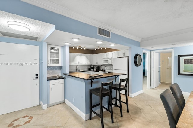 3725 S Ocean Dr Unit 1224, Hollywood, FL 33019 - kitchen featuring crown molding, white appliances, light tile patterned floors, dark countertops, and a sink