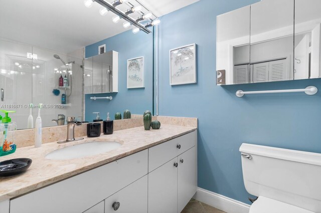 3725 S Ocean Dr Unit 1224, Hollywood, FL 33019 - bathroom featuring vanity, a stall shower, toilet, tile patterned flooring, and baseboards