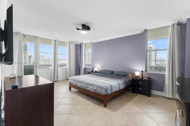 3725 S Ocean Dr Unit 1224, Hollywood, FL 33019 - bedroom featuring a textured ceiling, light tile patterned flooring, access to exterior, baseboards, and ornamental molding