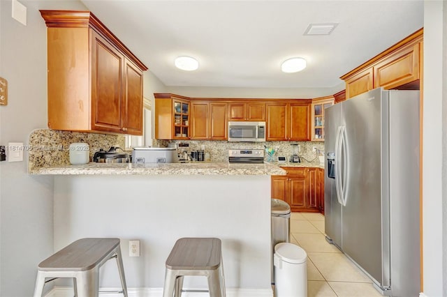 14521 SW 29th Ter Unit 14521, Miami, FL 33175 - kitchen featuring appliances with stainless steel finishes, a peninsula, backsplash, and glass insert cabinets