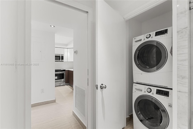 401 Ocean Dr Unit 221, Miami Beach, FL 33139 - laundry area featuring stacked washer / dryer and baseboards