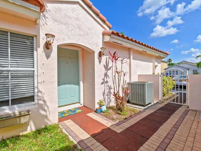 18424 NW 21st St, Pembroke Pines, FL 33029 - view of exterior entry with central air condition unit, stucco siding, and a tiled roof