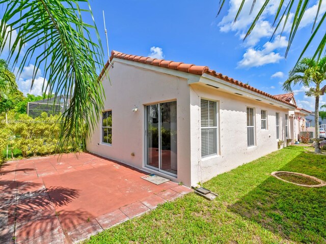 18424 NW 21st St, Pembroke Pines, FL 33029 - back of property with stucco siding, a lawn, a tiled roof, and a patio
