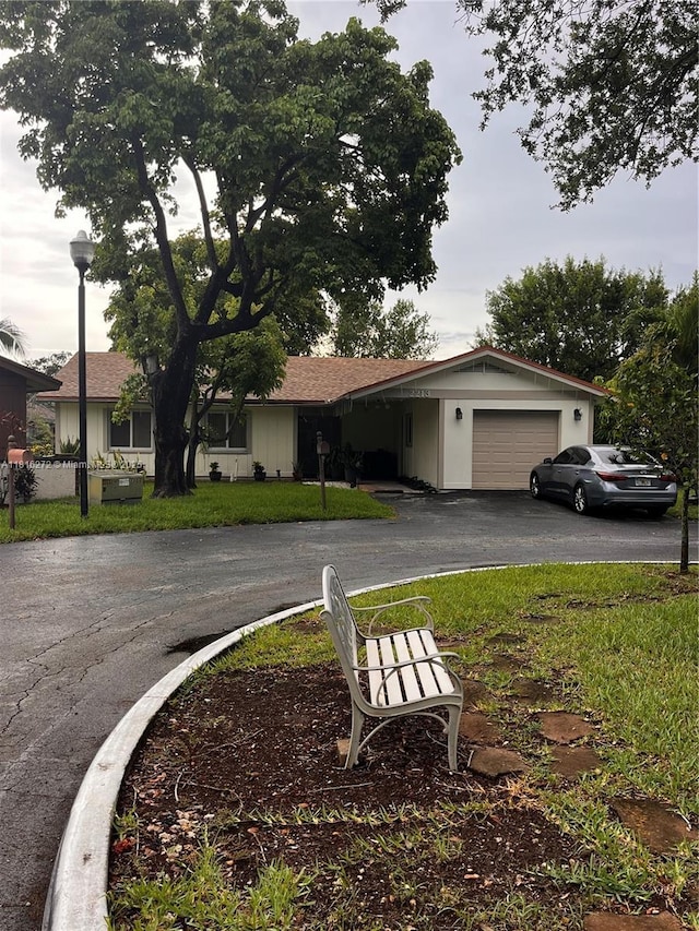 2213 Nova Village Dr, Davie, FL 33317 - view of front of home with asphalt driveway, an attached garage, a front yard, and a shingled roof