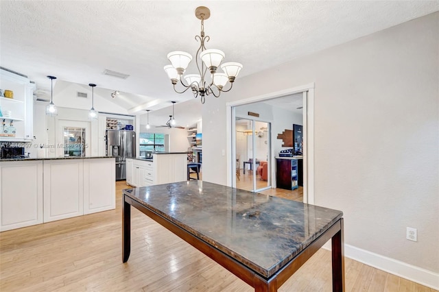 717 SW Aster Rd, Port St Lucie, FL 34953 - dining area with lofted ceiling, a chandelier, light wood-style flooring, baseboards, and a textured ceiling