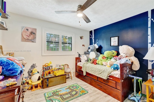 717 SW Aster Rd, Port St Lucie, FL 34953 - bedroom featuring wood finished floors, a textured ceiling, and a ceiling fan