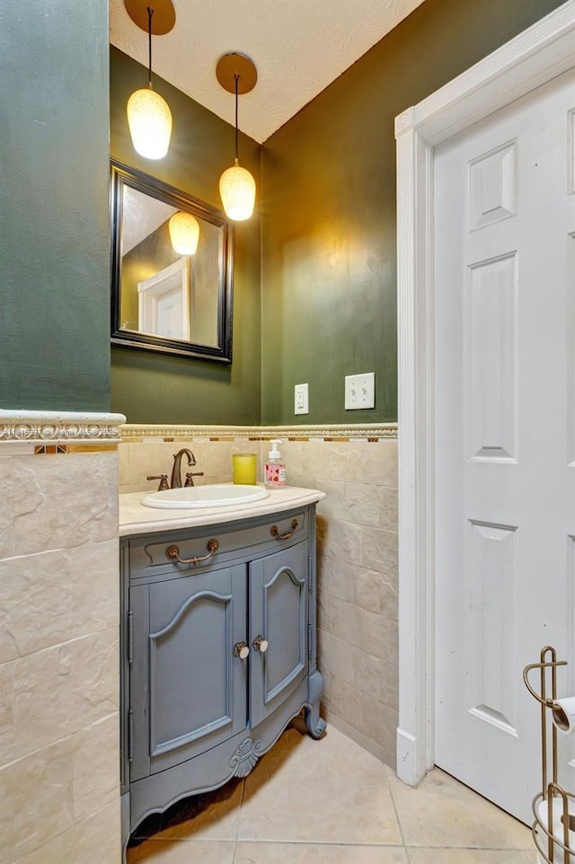717 SW Aster Rd, Port St Lucie, FL 34953 - bathroom featuring tile walls, tile patterned flooring, vanity, and wainscoting
