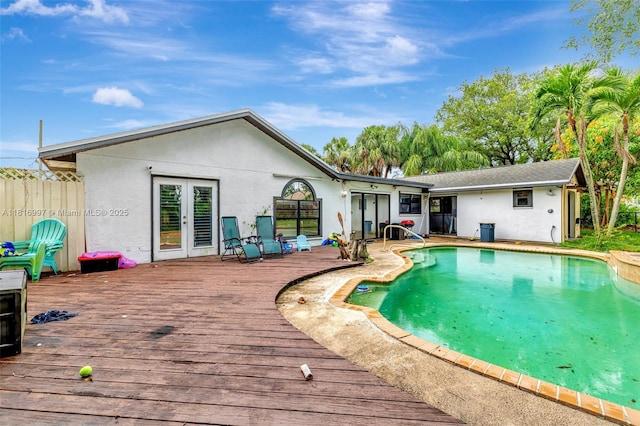 717 SW Aster Rd, Port St Lucie, FL 34953 - rear view of house with french doors, a wooden deck, and stucco siding