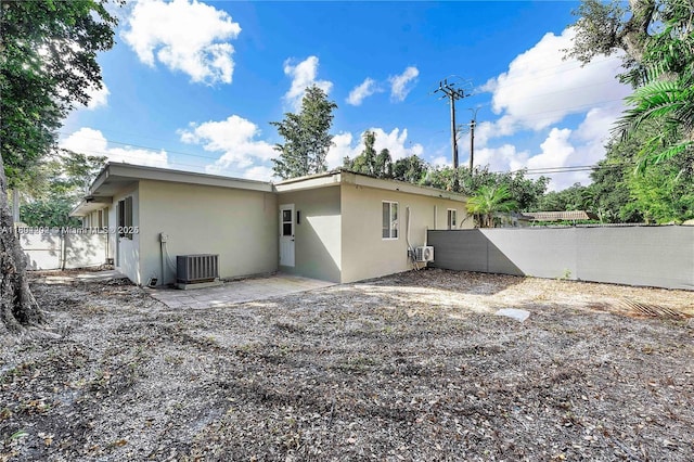 3655 Stirling Rd, Hollywood, FL 33312 - back of house with stucco siding and central AC