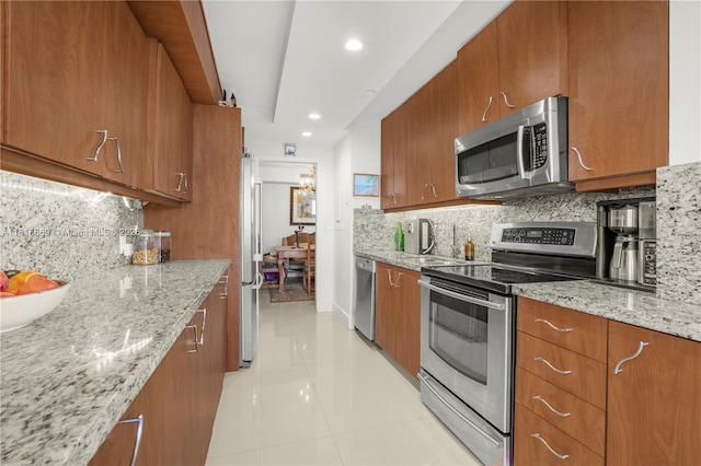 1000 Quayside Ter Unit 1107, Miami, FL 33138 - kitchen featuring appliances with stainless steel finishes, brown cabinetry, light tile patterned floors, decorative backsplash, and recessed lighting