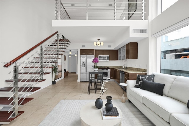 41 SE 5th St Unit 517, Miami, FL 33131 - living area with a towering ceiling, stairway, light tile patterned flooring, and a chandelier