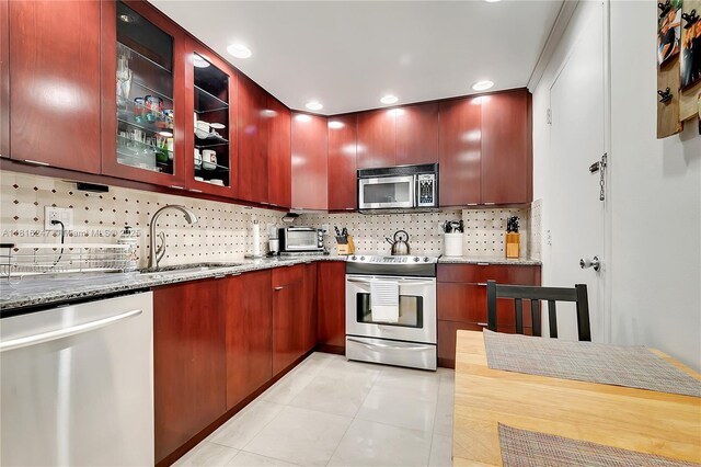 4250 Galt Ocean Dr Unit 7D, Fort Lauderdale, FL 33308 - kitchen with stainless steel appliances, light tile patterned floors, decorative backsplash, stone countertops, and recessed lighting