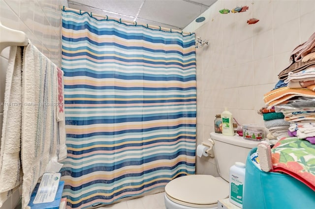 8635 NW 8th St Unit 104, Miami, FL 33126 - bathroom with tile walls, a shower with shower curtain, and tile patterned floors