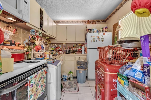 8635 NW 8th St Unit 104, Miami, FL 33126 - kitchen featuring white appliances, a textured ceiling, light tile patterned floors, and light countertops