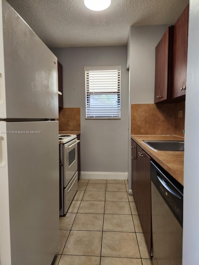 7095 NW 179th St Unit 206, Hialeah, FL 33015 - kitchen with freestanding refrigerator, electric stove, stainless steel dishwasher, a textured ceiling, and a sink