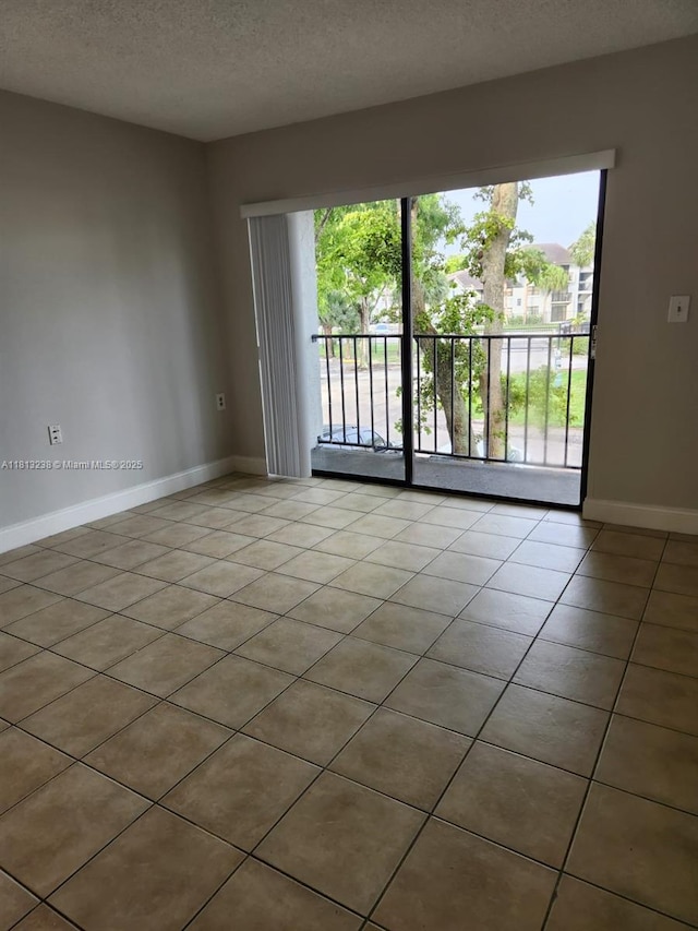 7095 NW 179th St Unit 206, Hialeah, FL 33015 - unfurnished room with baseboards, tile patterned floors, and a textured ceiling