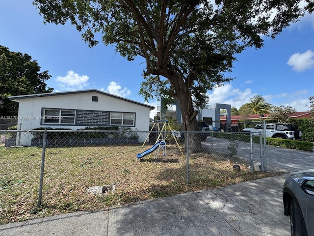 1226 NE 112th St, Miami, FL 33161 - view of front facade featuring a playground and stucco siding