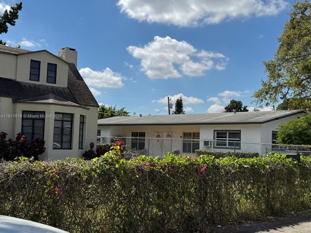 1226 NE 112th St, Miami, FL 33161 - back of property with stucco siding, a shingled roof, and a chimney