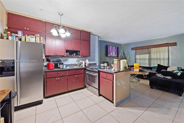 1226 NE 112th St, Miami, FL 33161 - kitchen with stainless steel appliances, red cabinetry, a chandelier, and light tile patterned floors