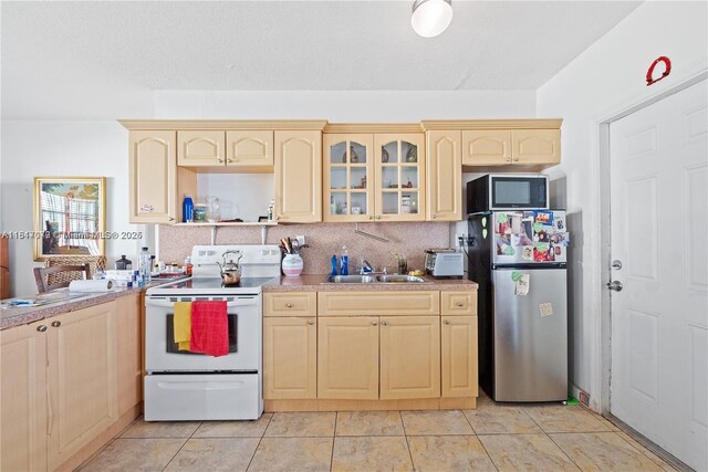 1226 NE 112th St, Miami, FL 33161 - kitchen with appliances with stainless steel finishes, light brown cabinets, a sink, and glass insert cabinets