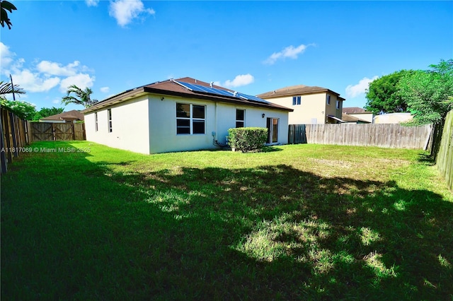 18972 SW 318th Ter, Homestead, FL 33030 - rear view of property with solar panels, stucco siding, and a fenced backyard