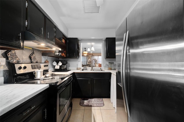 2430 N Dunwoodie Rd, Avon Park, FL 33825 - kitchen with appliances with stainless steel finishes, under cabinet range hood, dark cabinetry, and light tile patterned floors