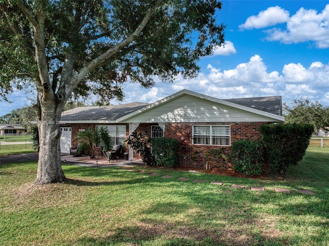 2430 N Dunwoodie Rd, Avon Park, FL 33825 - ranch-style house featuring brick siding, a front yard, and a garage