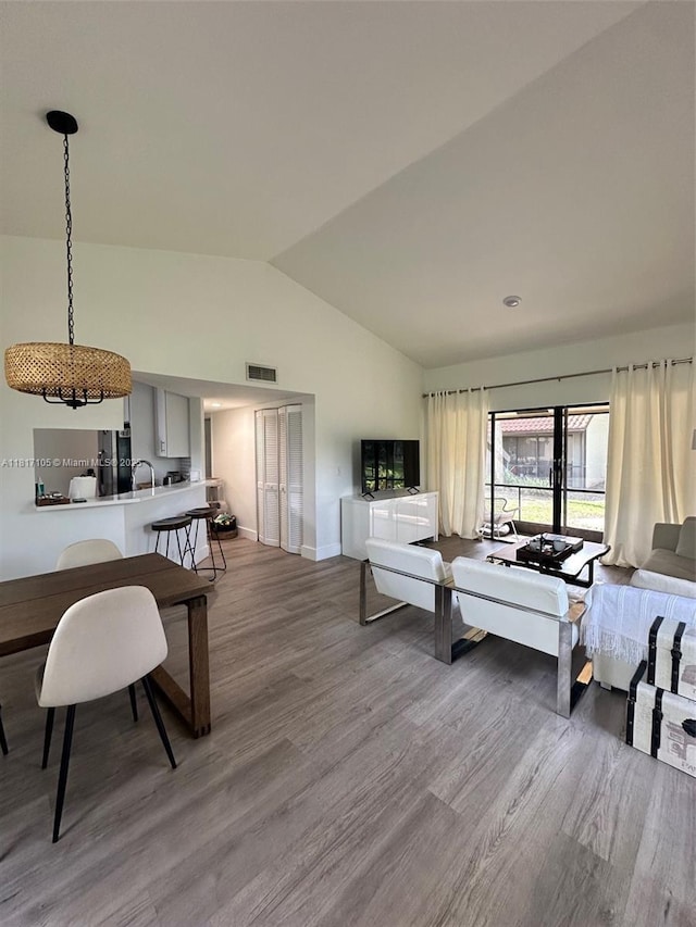 12 Via De Casas Sur Unit 104, Boynton Beach, FL 33426 - living room with vaulted ceiling, wood finished floors, and baseboards