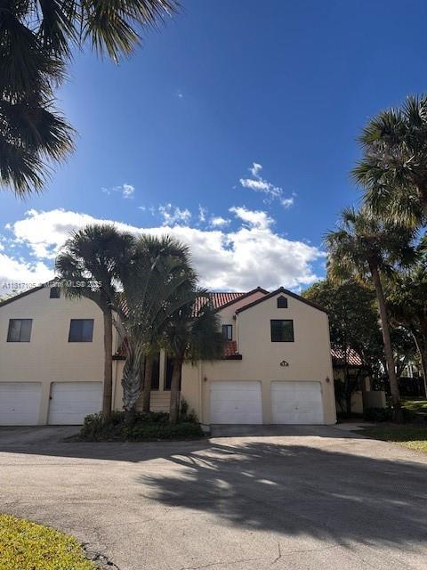 12 Via De Casas Sur Unit 104, Boynton Beach, FL 33426 - view of front facade with stucco siding and a garage