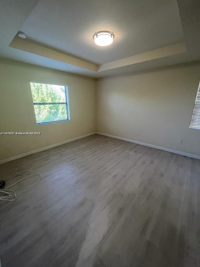 3385 W 86th Ter, Hialeah, FL 33018 - empty room featuring a raised ceiling, wood finished floors, and baseboards