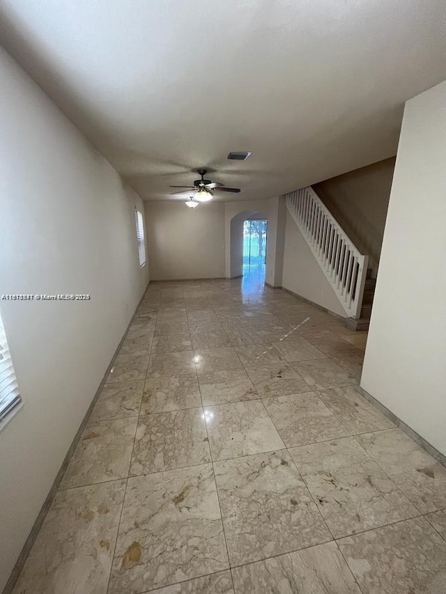 3385 W 86th Ter, Hialeah, FL 33018 - empty room with a ceiling fan, arched walkways, stairway, and baseboards