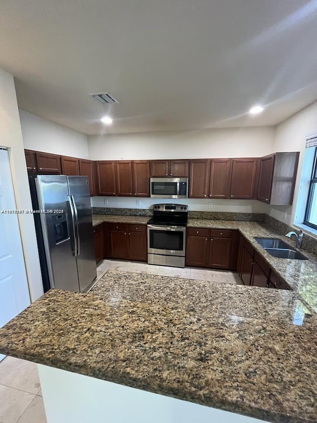3385 W 86th Ter, Hialeah, FL 33018 - kitchen with stainless steel appliances, a sink, dark stone counters, light tile patterned floors, and recessed lighting