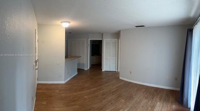3705SW 27 Th St Unit 416, Gainesville, FL 32608 - unfurnished room with wood finished floors, baseboards, and a textured ceiling