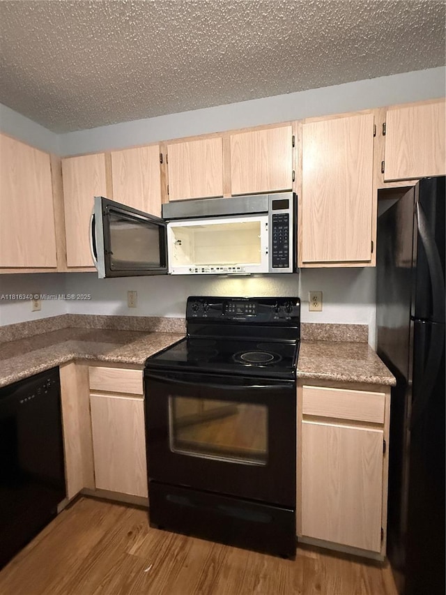 3705SW 27 Th St Unit 416, Gainesville, FL 32608 - kitchen with black appliances, light brown cabinetry, and wood finished floors