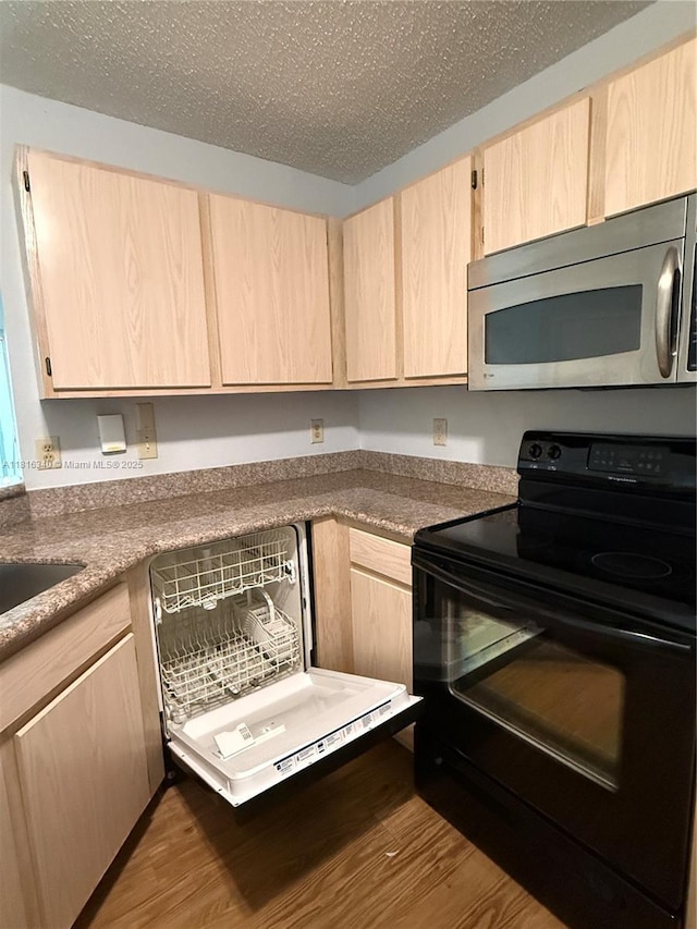 3705SW 27 Th St Unit 416, Gainesville, FL 32608 - kitchen with black / electric stove, stainless steel microwave, light brown cabinets, wood finished floors, and a textured ceiling