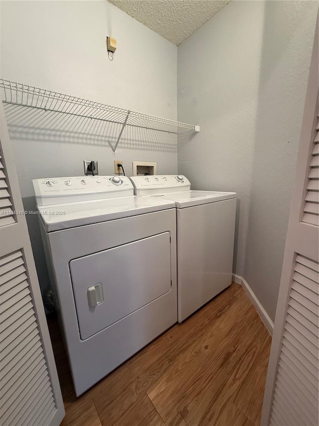 3705SW 27 Th St Unit 416, Gainesville, FL 32608 - laundry area with washer and clothes dryer, wood finished floors, a textured ceiling, and baseboards